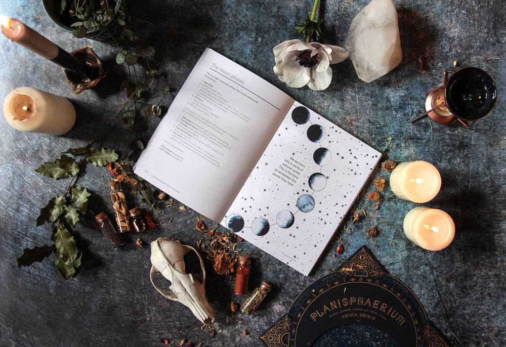 moon book on how to attune to the moon with candles flowers and a sheep's skull