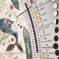 Load image into Gallery viewer, Close-up of a calendar with astrological symbols and a decorative design.
