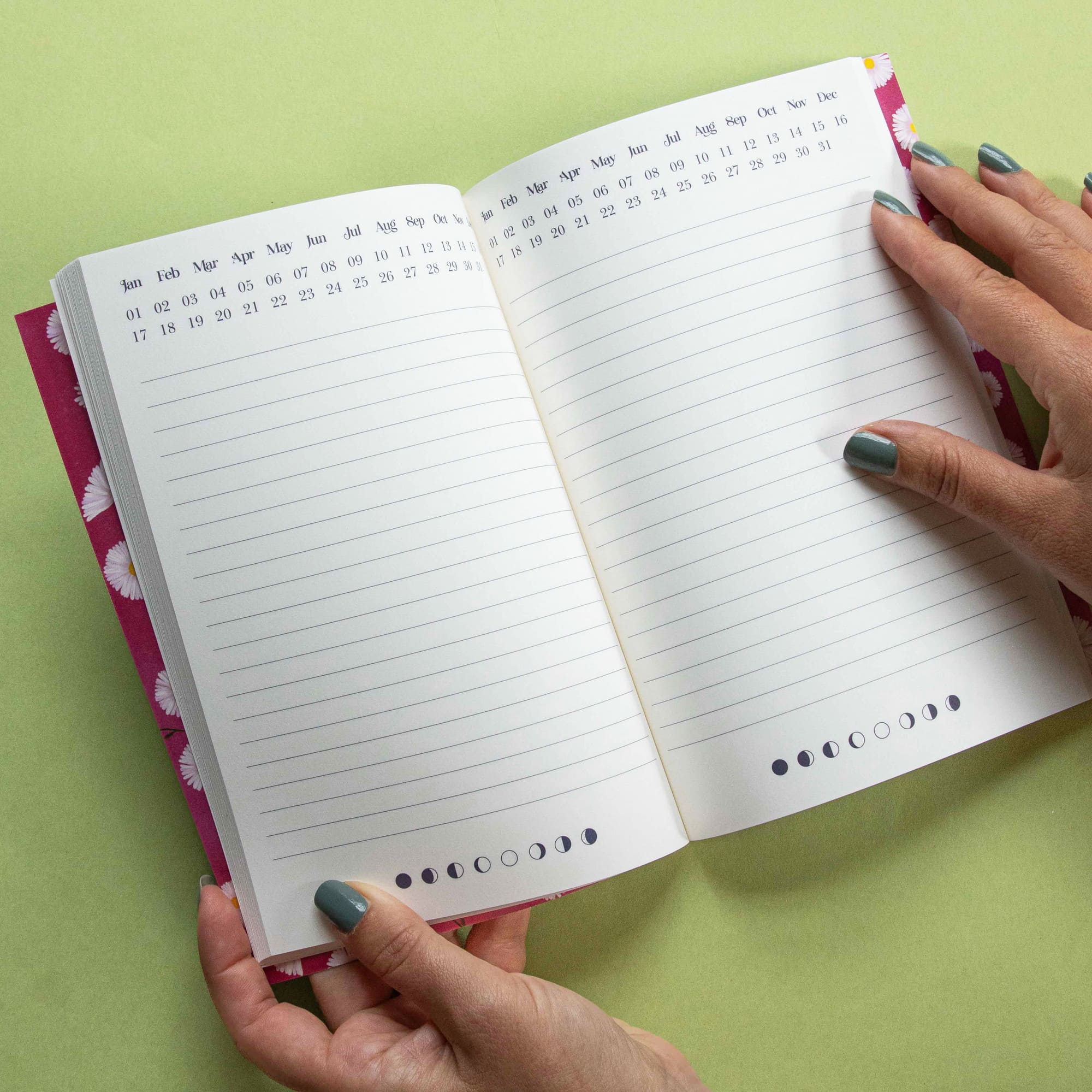 Open notebook with lined pages and calendar on a green background